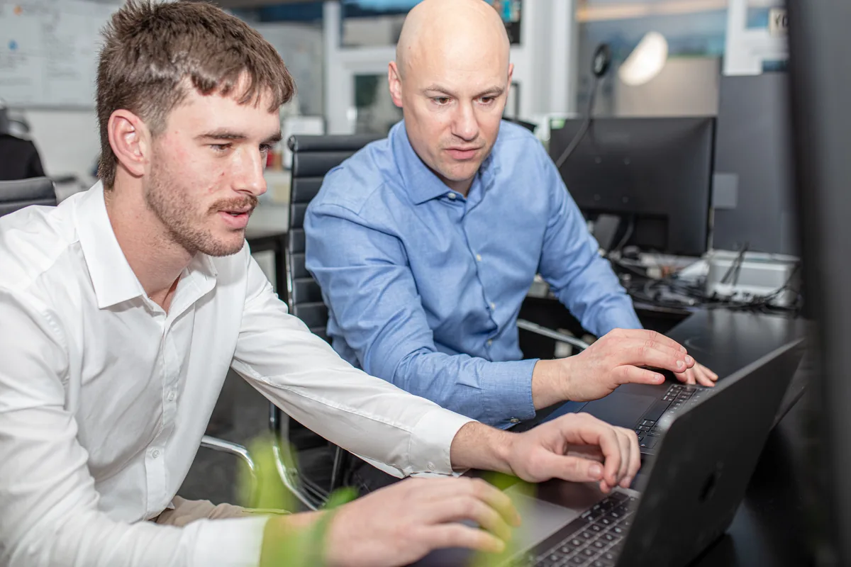 David and Luke from Halizona working at laptops in the office